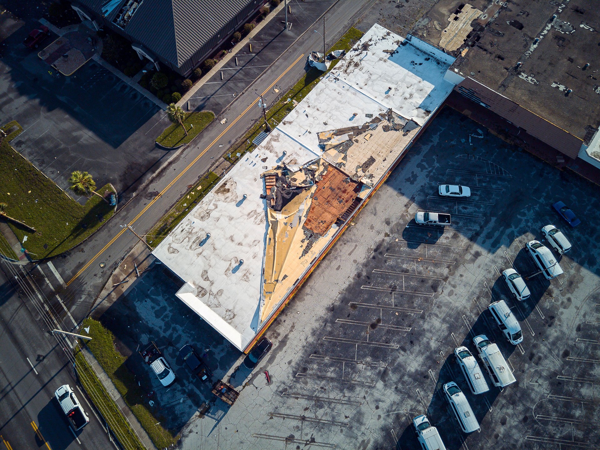 Shop roof destruction after storm: building decimated, and roof twisted after hurricane in Perry, North Florida. Directly above